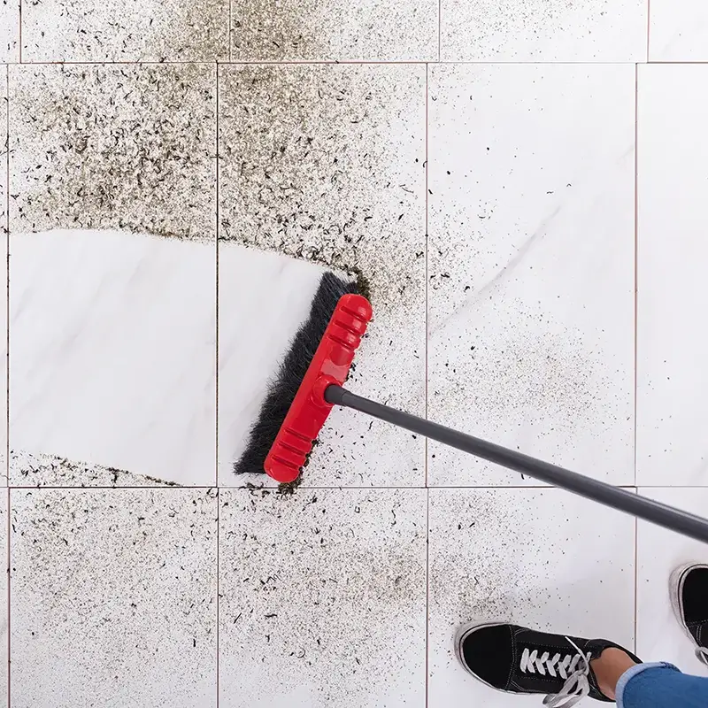 sweeping up allergens on a tile floor 