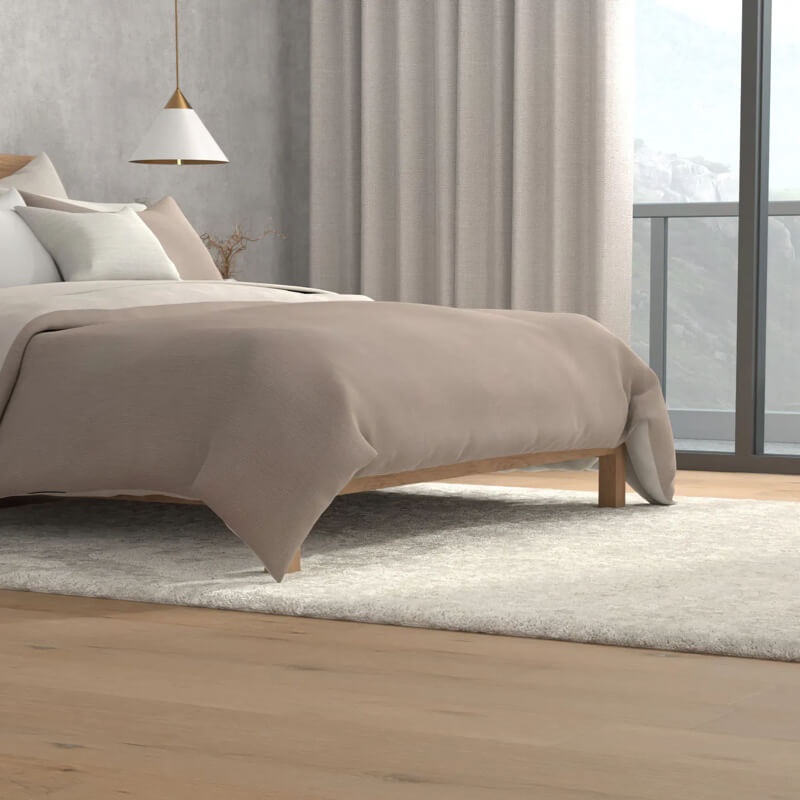 bedroom with light colored wood floors, rug and window treatments