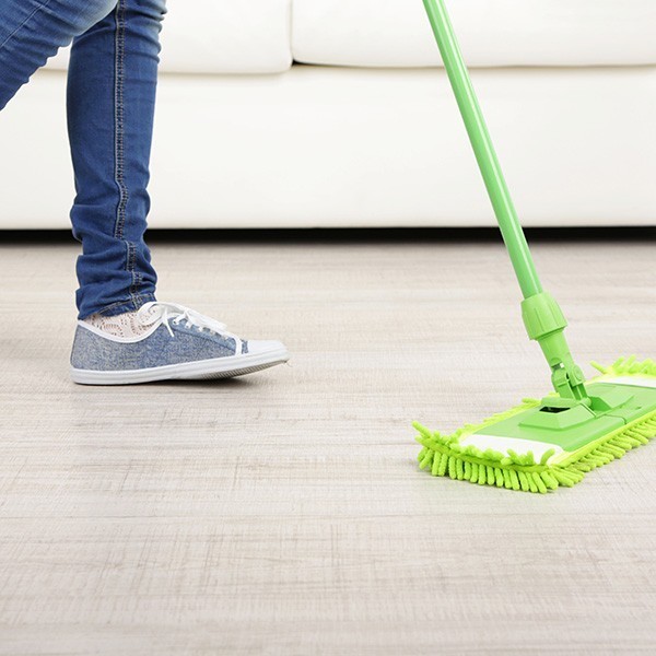 Woman with mop cleaning wooden floor from dust | Classic Flooring Center