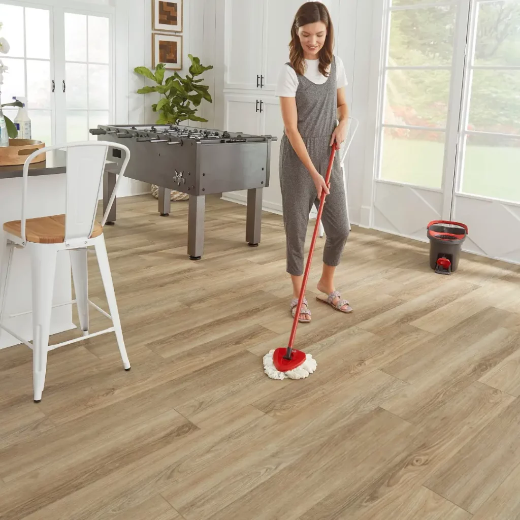 woman cleaning luxury vinyl plank flooring in dining area 