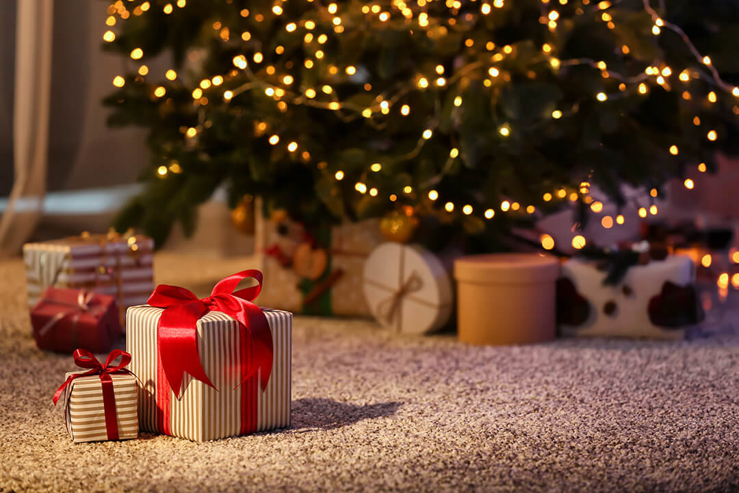 gifts on floor in front of a Christmas tree