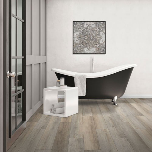 gray luxury vinyl plank waterproof flooring in a bathroom with a claw bathtub 