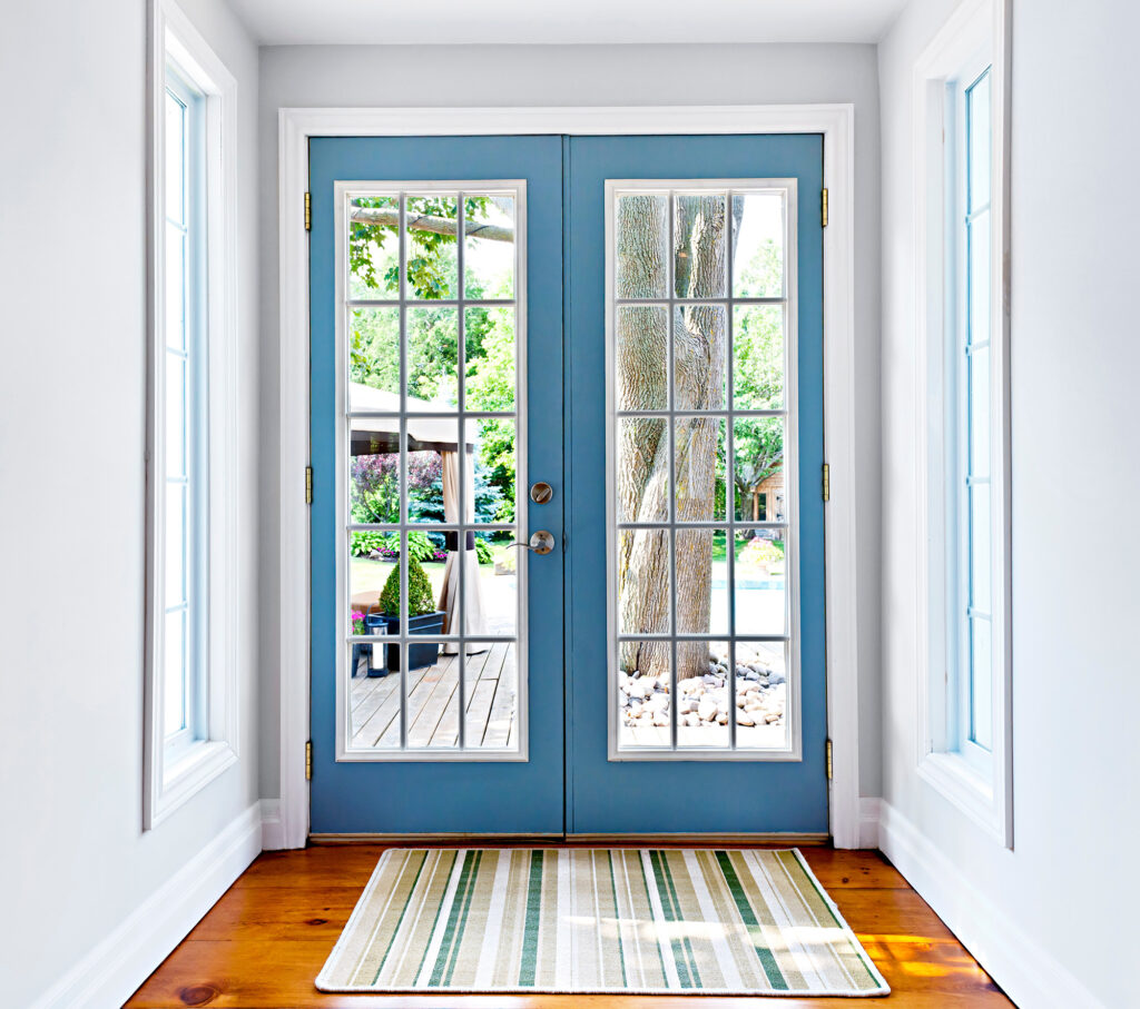 contemporary entryway with hardwood flooring, striped area rug and glass door with blue frame
