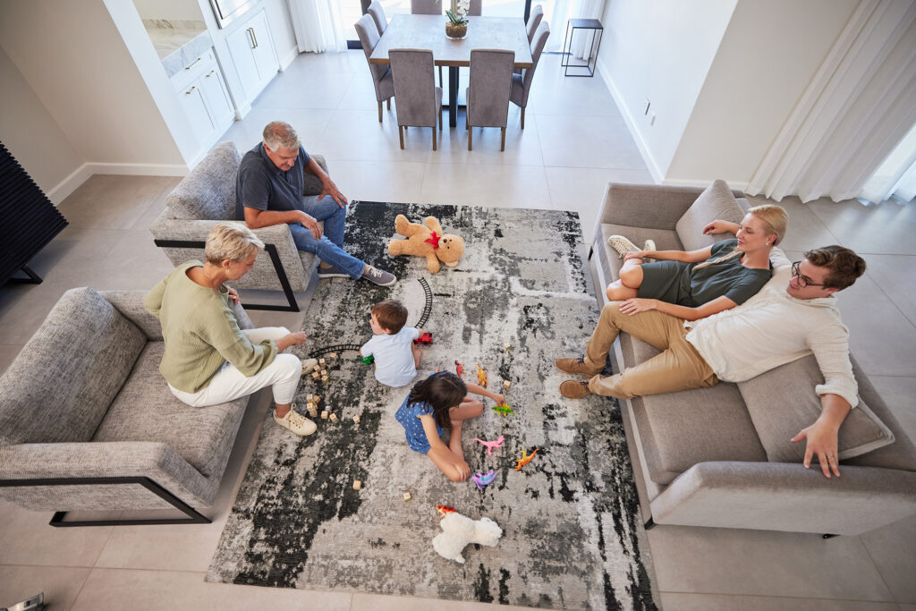 overhead view of multi-generational family on rug in living room 